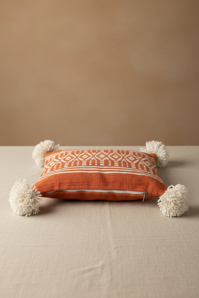 Housse de coussin berbère terracotta 45x45cm vue de profil – Pompons en laine écrue, tissage artisanal marocain