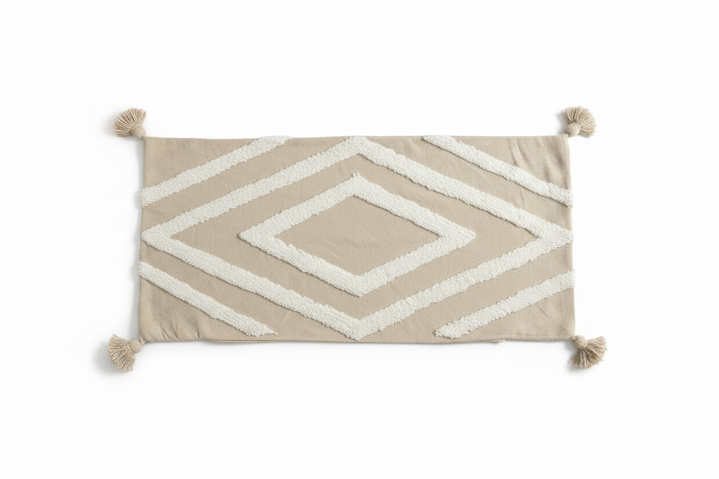 Vue de face housse de coussin XL beige sable 98x50 cm, grand motif losange tufted blanc et pompons aux quatre coins, pièce unique artisanale

