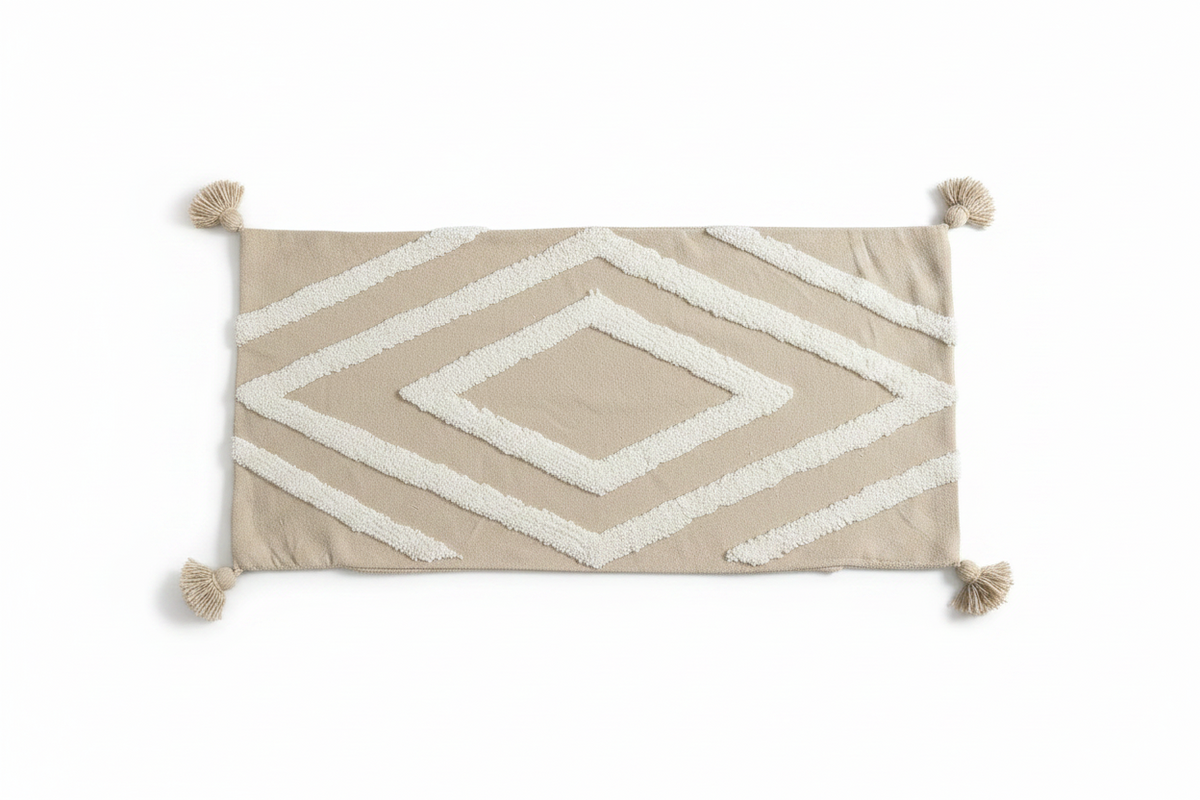 Vue de face housse de coussin XL beige sable 98x50 cm, grand motif losange tufted blanc et pompons aux quatre coins, pièce unique artisanale
