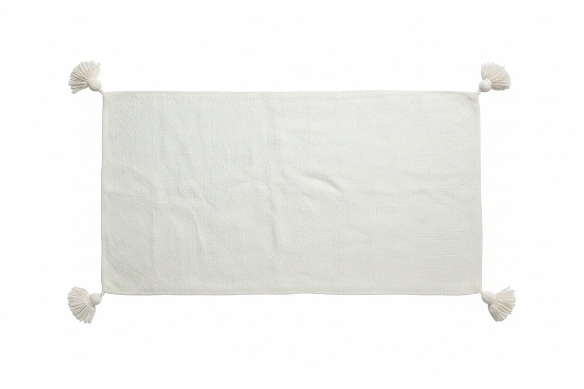 "Housse de coussin XL blanc écru avec pompons aux quatre coins vue de face sur fond blanc — dimensions 98x50 cm, artisanat marocain fait main"