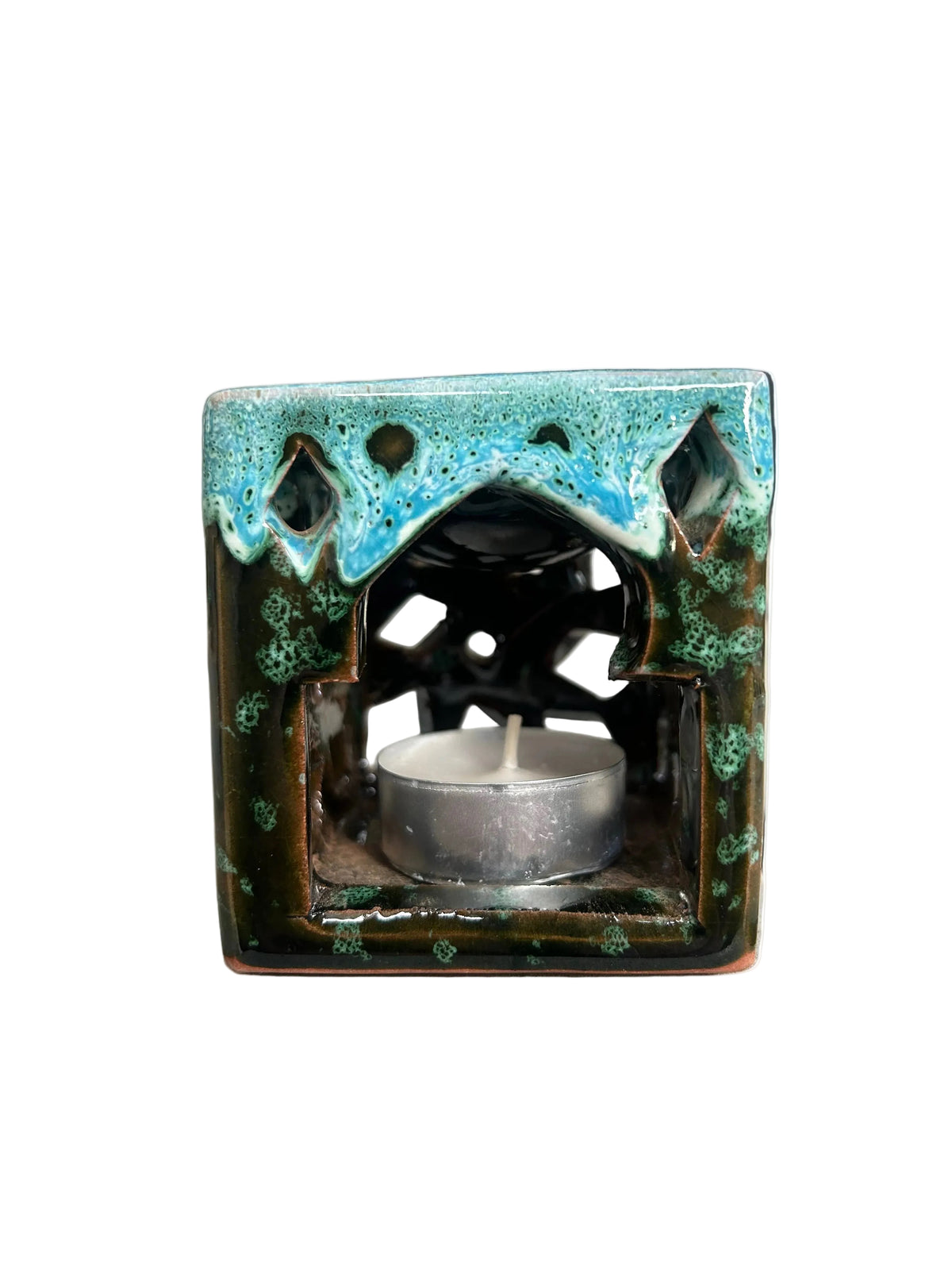 Brûle-parfum carré en céramique bleu turquoise, vert et marron, avec finition mouchetée, motifs ajourés et bougie chauffe-plat à l’intérieur.