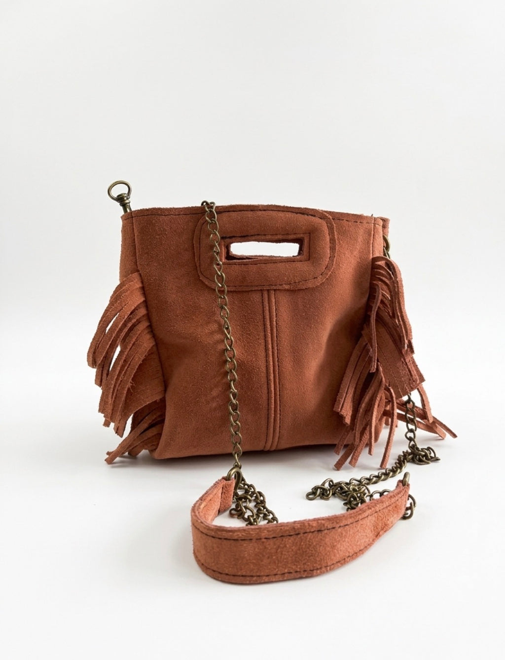 Petit sac Sienna en cuir pêche cuivrée, avec franges latérales, poignée intégrée et bandoulière chaîne.