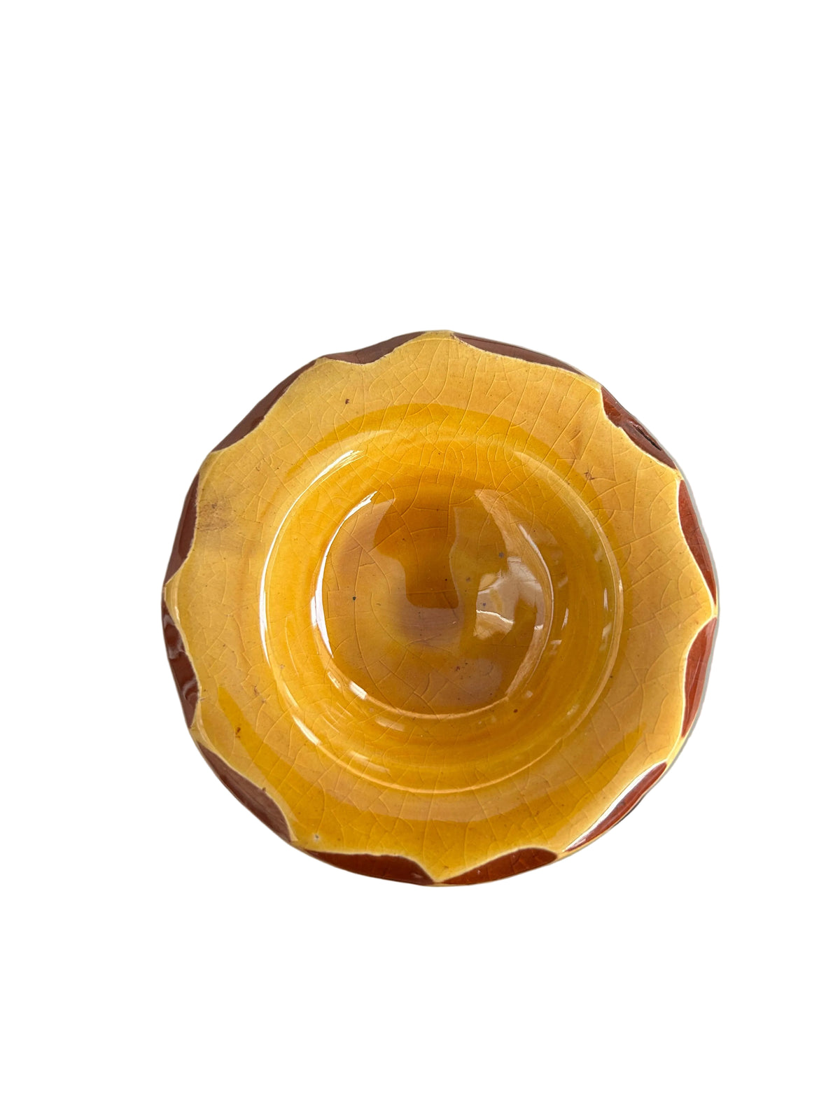 Brûle-parfum en céramique jaune, avec ouvertures ajourées, coupelle à bord ondulé et bougie chauffe-plat allumée à l’intérieur.