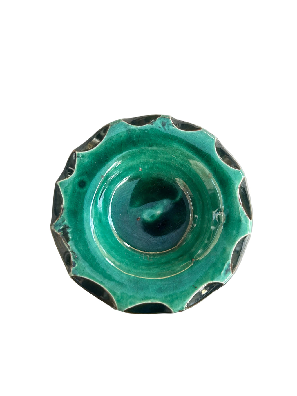 Brûle-parfum en céramique vert foncé brillant, avec lunes et étoiles ajourées, coupelle à bord ondulé et bougie chauffe-plat allumée.