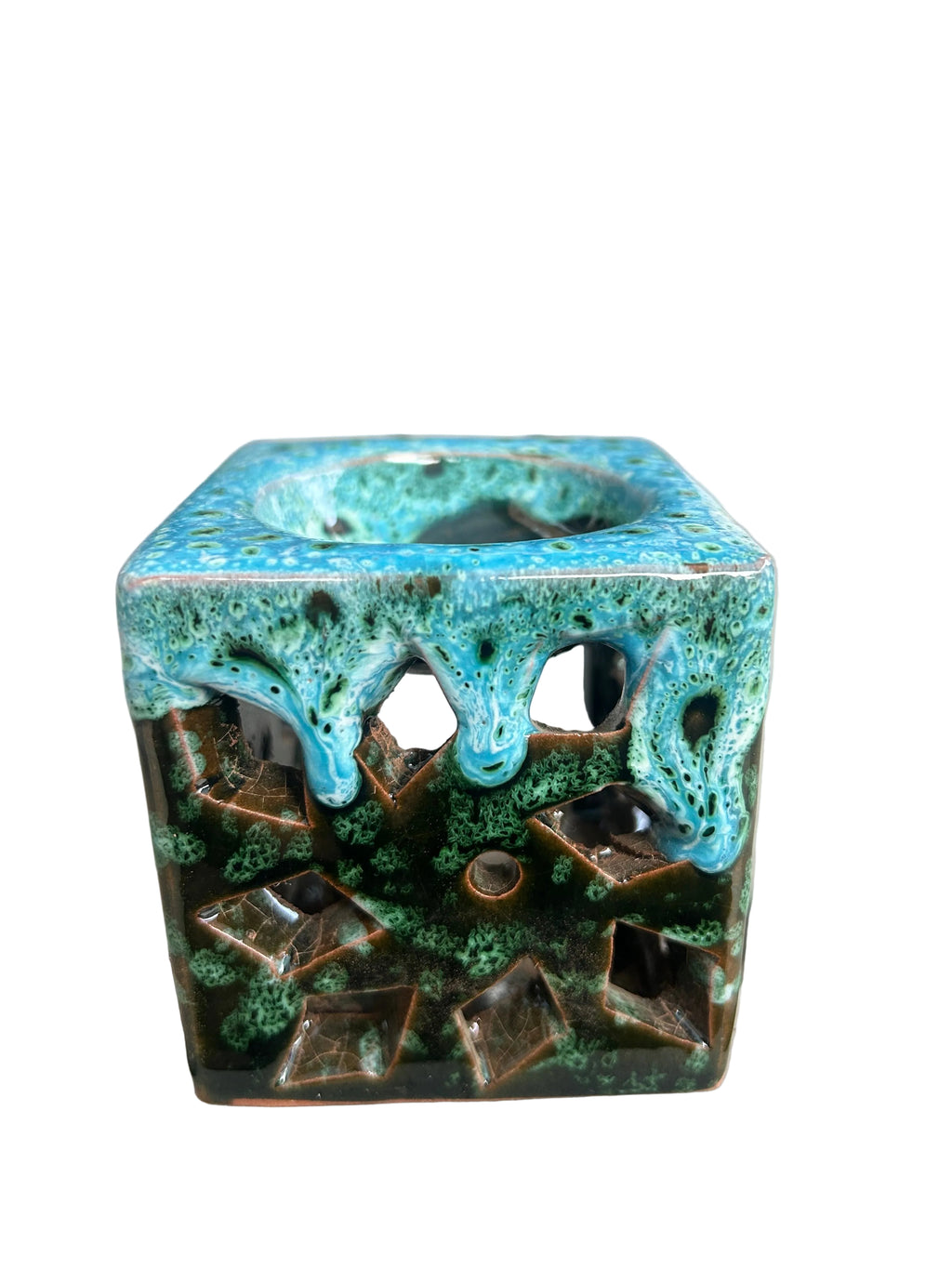 Brûle-parfum carré en céramique bleu turquoise, vert et marron, avec finition mouchetée, motifs ajourés et bougie chauffe-plat à l’intérieur.