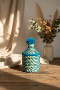 Petit panier berbère tressé avec couvercle et pompon bleu turquoise — artisanat marocain fait main
