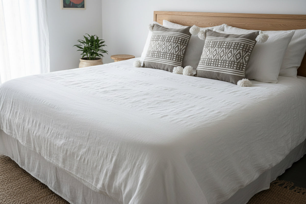Housse de coussin berbère taupe à pompons blancs fait main – décoration chambre bohème marocaine