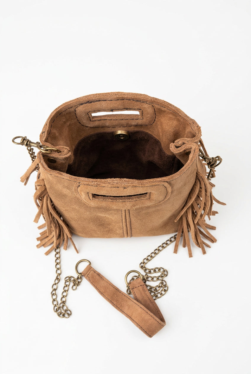 
« Sac Sienna en cuir camel à franges, avec bandoulière chaîne et poignées intégrées, style bohème. »