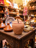 Tirelire artisanale en terre cuite fait main – poterie marocaine dans un souk