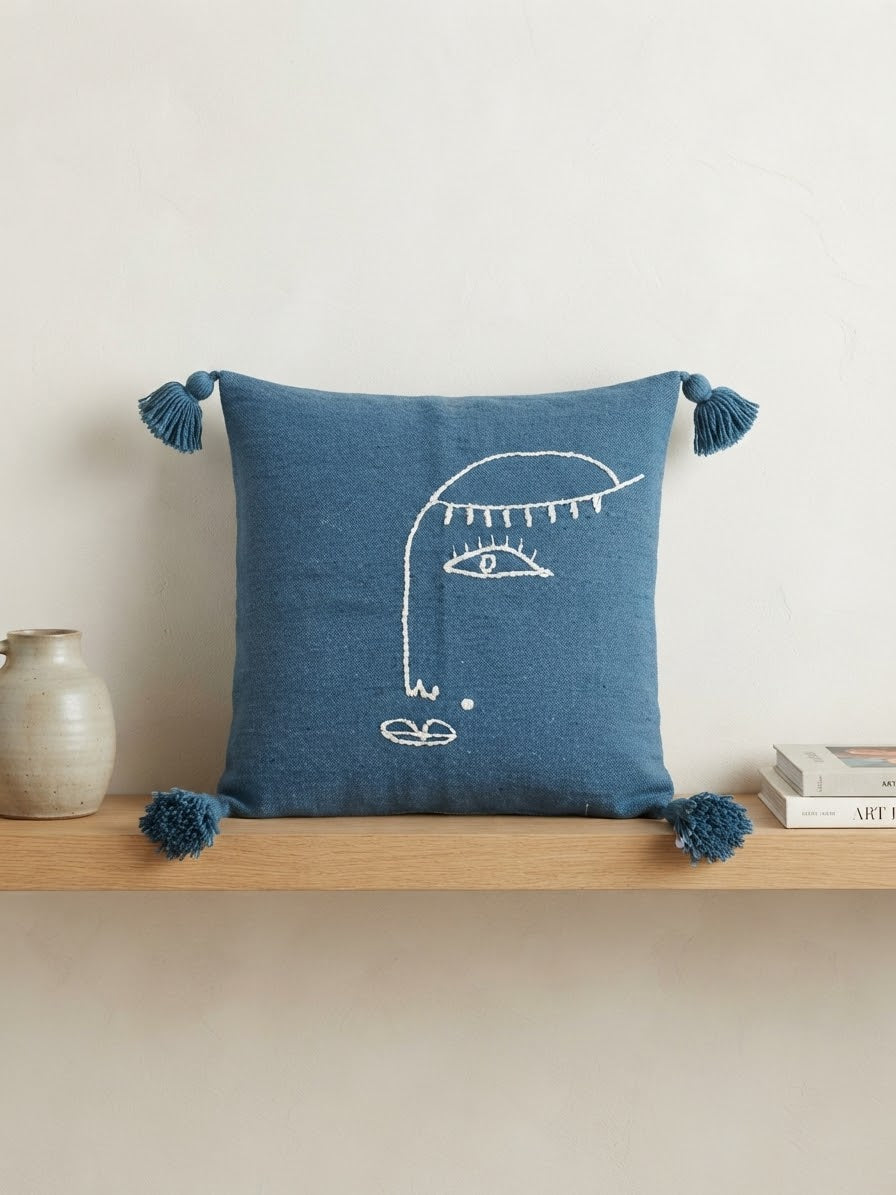 Housse de coussin brodée visage abstrait – fil blanc sur fond bleu pétrole – pompons – 50x60 cm