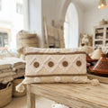 Coussin lombaire bohème écru à motifs losanges et pompons, broderie berbère caramel, fait main au Maroc – décoration boho chic