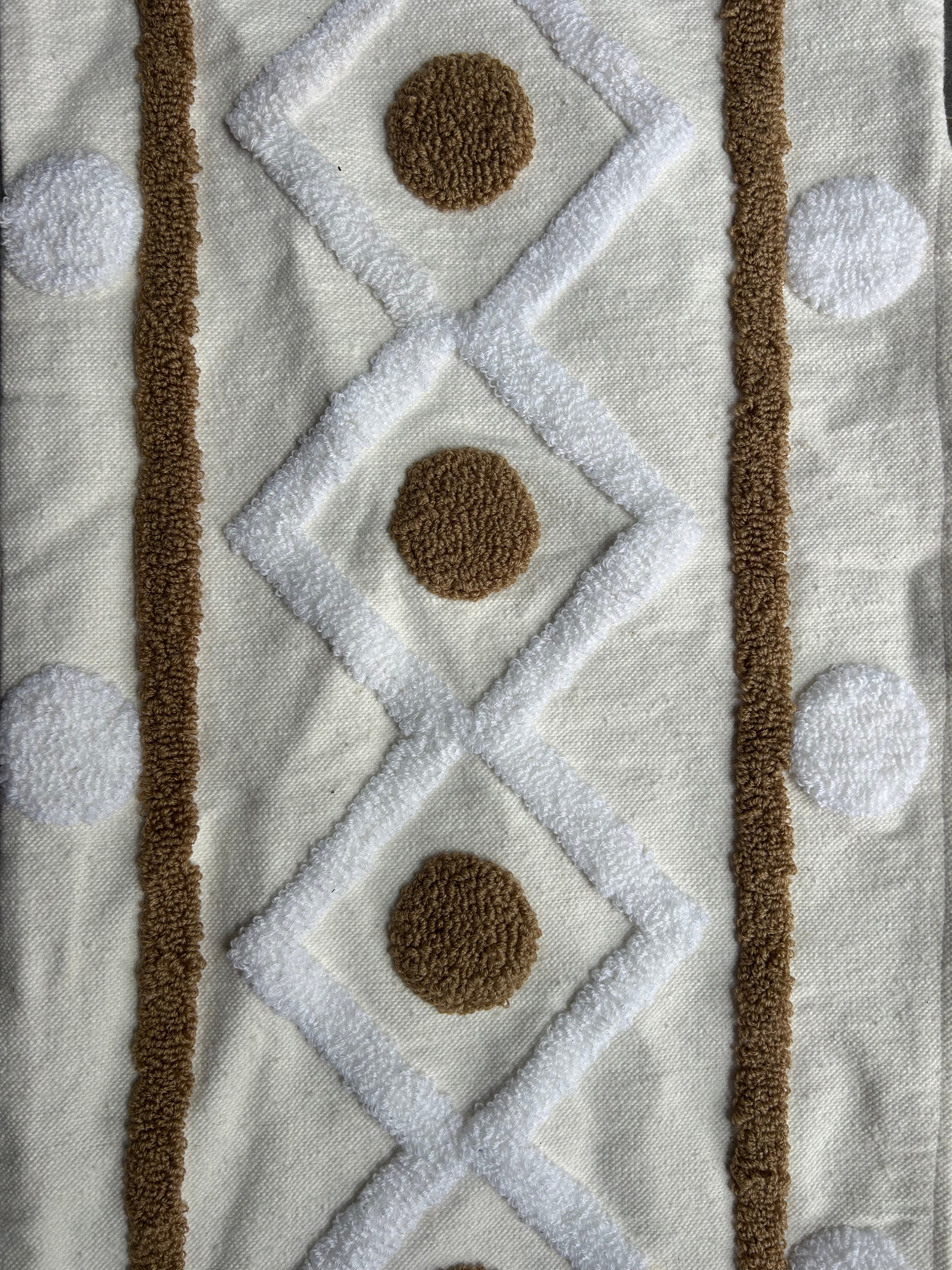 Détail texture broderie punch needle housse de coussin berbère XL, losanges ivoire et médaillons ronds camel en relief sur coton naturel