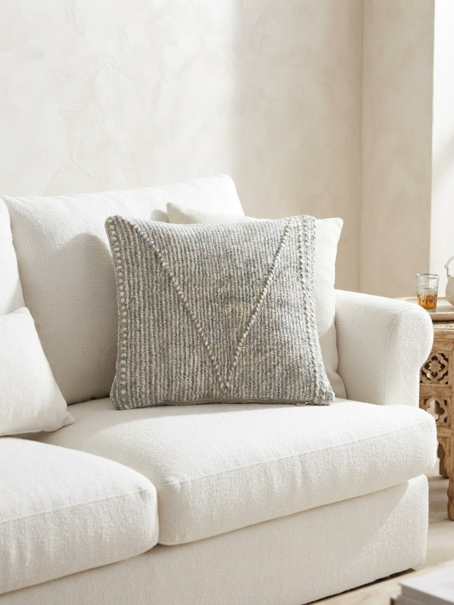 Housse de coussin artisanale marocaine gris chiné sur canapé blanc – intérieur bohème chic