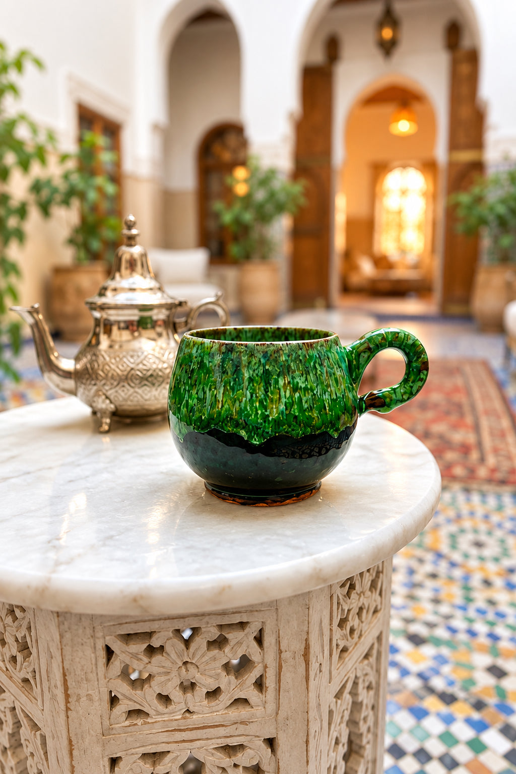 Tasse Émeraude à la forme arrondie, avec anse, finition brillante verte nuancée et base brun foncé.