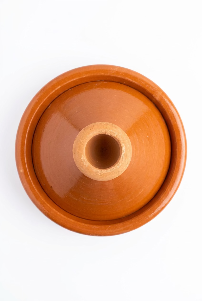  Vue de dessus du tajine marocain fermé, couleur terre cuite, sur fond blanc.